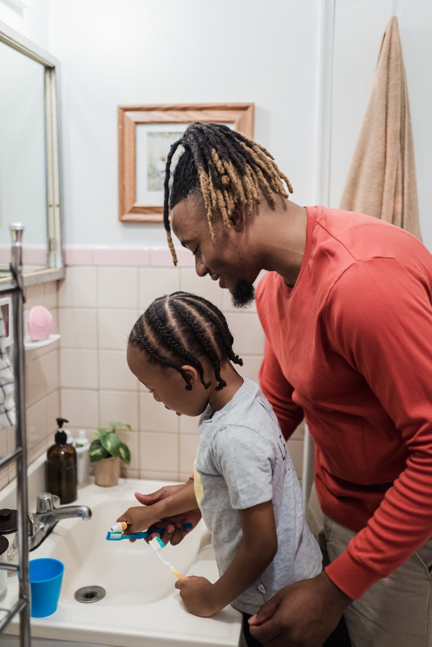 father and son brushing teeth